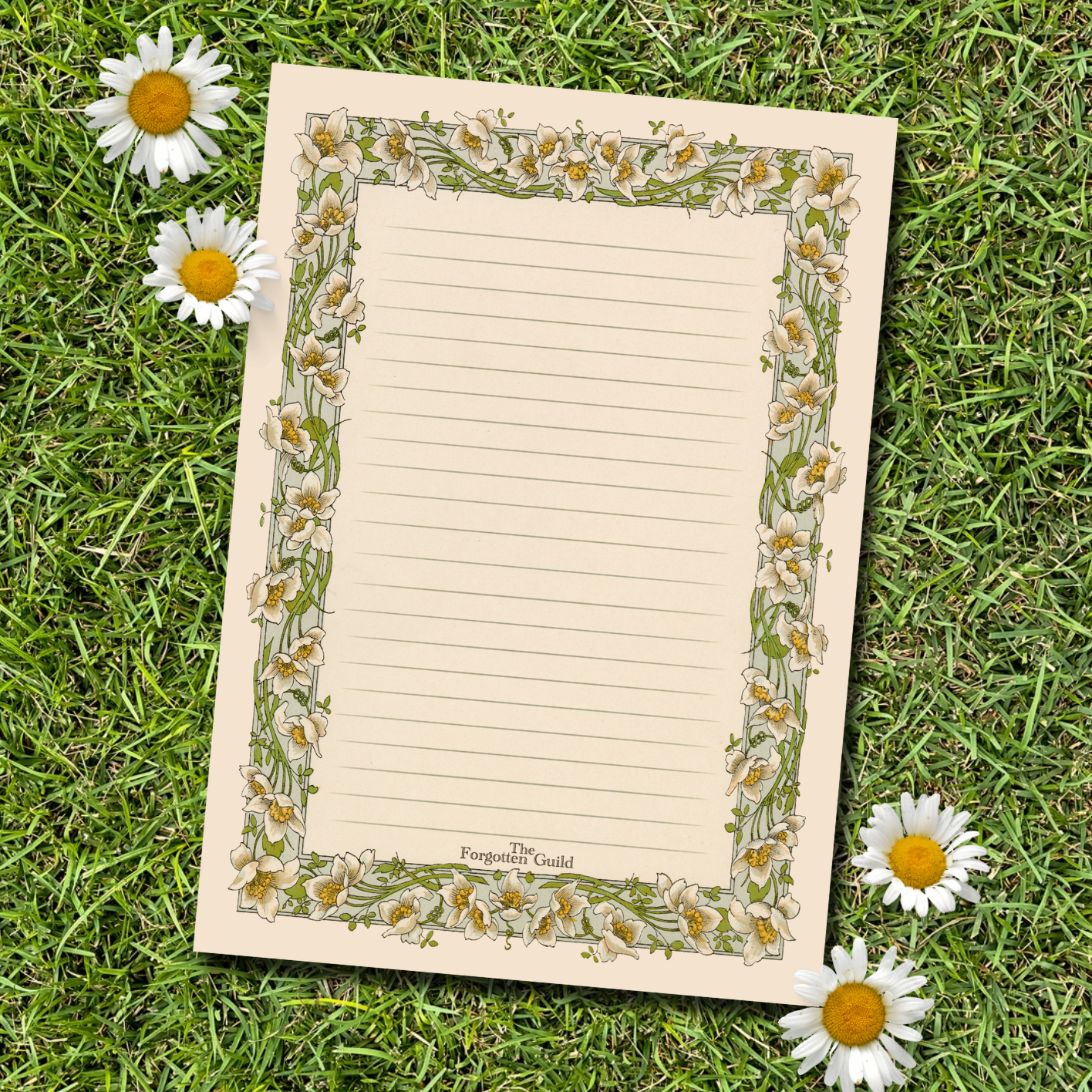 Notebook with floral design on grass with daisies
